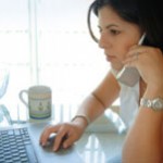 Woman on phone using computer